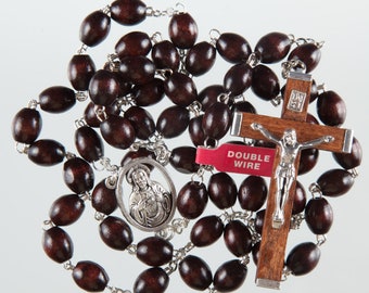 May include: A rosary with dark brown wooden beads and silver-toned metal accents. The rosary features a crucifix with a silver figure of Jesus and a red tag that reads "DOUBLE WIRE". An oval pendant with a religious image is also present.