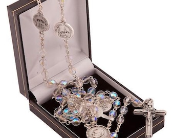 May include: A silver rosary with iridescent glass beads and a silver crucifix in a black velvet box. The rosary features two silver medallions with religious imagery.