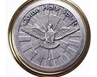 May include: A round, silver-colored religious medallion with a gold-colored rim. The medallion features a dove with outstretched wings at the center, surrounded by the words "Come Holy Spirit". The background has a sunburst design.