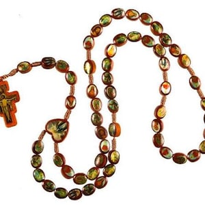 May include: A brown wooden rosary with colorful images of saints and religious figures. The rosary has a crucifix with a figure of Jesus Christ.
