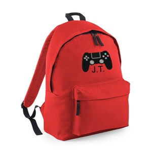 May include: Red backpack with a black video game controller and the initials "J.T." embroidered on the front.