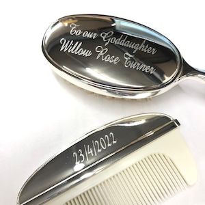 May include: A silver baby hair brush and comb set with engraved text. The brush has the inscription "To our Goddaughter Willow Rose Turner". The comb has the inscription "23/4/2022".