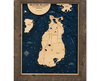 Op de afbeelding: Een 16x20 inch 3D bathymetrische houten kaart van Beaver Island, Charlevoix County, Michigan, met gelaagde lichte houten landmassa's tegen een diepblauwe waterachtergrond, gevat in een rustieke bruine houten lijst.
