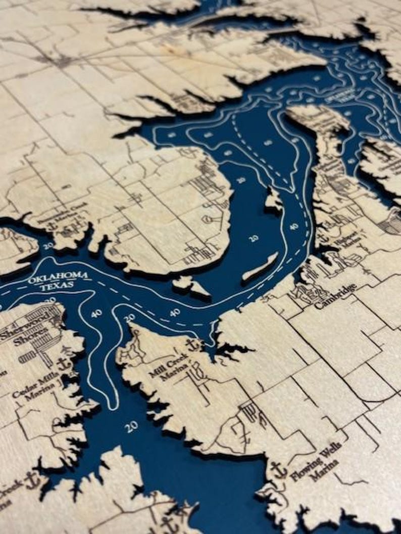 The image is a detailed map of a large body of water, likely a lake or a river, with various geographical features and labels. The map appears to be in a wooden frame, giving it a rustic and antique appearance.
