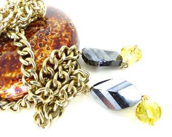 Collar vintage de cadena gruesa de oro con forma de Y, con hematita facetada en tono bronce y cuentas de cristal dorado en los extremos. Pieza única para tu colección.