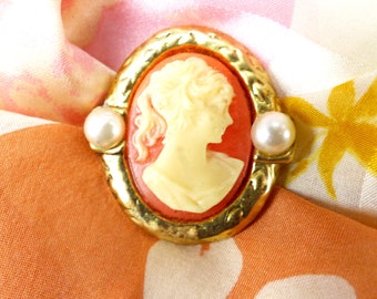 Magnetic scarf pin or brooch. Coral color & cream profile cameo set in an open gold frame with pearl detail. Silk back button. Gift packaged