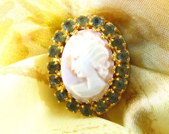 Gorgeous vintage cream detailed profile cameo surrounded by green gray crystals and gold rope magnetic brooch. Silk back button.