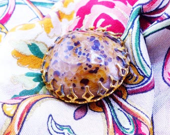 Speckled black & tan stone in a crown setting. Magnetic brooch. Silk back button. Heavy duty to use on fall and winter scarves and coats.