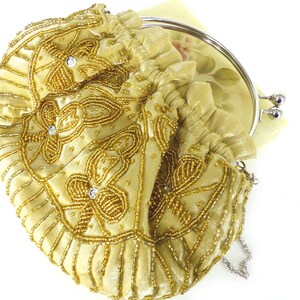 Puede incluir: Un bolso de mano de cuentas doradas con marco y cadena plateados. El bolso est&aacute; decorado con cuentas doradas y lentejuelas en un patr&oacute;n floral.