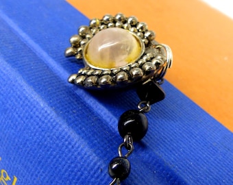One of a kind sweater clip or sweater guard. Antiqued silver setting with domed milk glass. Beaded connection chain. Comes gift packaged
