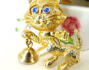 Coolest little gold raccoon  with a working tiny bell brooch pin with brilliant blue crystal eyes. Latch pin back. Comes gift packaged