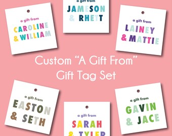 Könnte beinhalten: Satz von sechs weißen Geschenkanhängern mit buntem Text. Jeder Anhänger trägt die Aufschrift "ein Geschenk von" gefolgt von zwei Namen. Die Namen sind: Caroline & William, Jameson & Rhett, Lainy & Mattie, Easton & Seth, Sarah & Tyler, Gavin & Jace.
