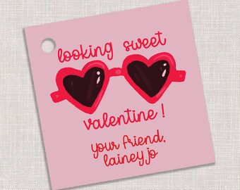 Könnte beinhalten: Rosafarbener Valentinstag-Geschenk-Anhänger mit einem Grafikmotiv von Herz-Sonnenbrillen und dem Text "looking sweet valentine! your friend, lainey jo"
