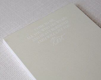 May include: A light green notepad with the text "Come to me. All you who are weary and heavy burdened and I will give you Rest" printed in white.