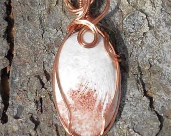 May include: A copper wire wrapped pendant featuring a white and pink agate stone. The pendant is hanging from a copper chain.