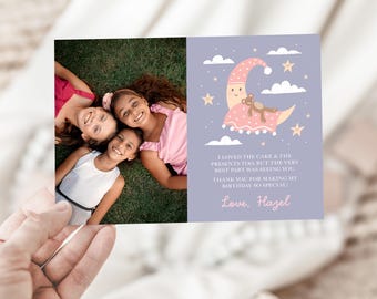 May include: A birthday card held in a hand, featuring a photo of three smiling girls on the left and a cartoon moon with a teddy bear on the right. Text reads: "I loved the cake & the presents too, but the very best part was seeing you! Thank you for making my birthday so special! Love, Hazel."