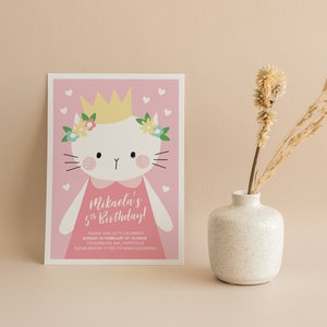 Może przedstawiać: R&oacute;żowe zaproszenie na urodziny z kresk&oacute;wkowym kotem w koronie i kwiatami. Tekst brzmi "Mikaela's 5th Birthday!" i zawiera szczeg&oacute;ły dotyczące przyjęcia.