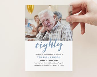 May include: A white invitation card with the word "eighty" in blue script. The card includes a photo of a smiling older man and text inviting guests to Ted Richardson's 80th birthday party on August 12th.