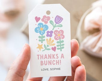 May include: White gift tag with a floral design in pastel colors. The tag features a variety of flowers, hearts, and stars. Text on the tag reads "THANKS A BUNCH!" and "LOVE, SOPHIE".