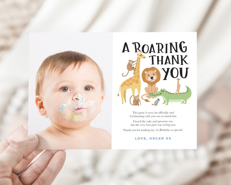 Pode incluir: Um cart&atilde;o de agradecimento com uma ilustra&ccedil;&atilde;o fofa de um beb&ecirc; com bolo no rosto e animais da selva. O texto diz "A Roaring Thank You. The party is over, I'm officially one! Celebrating with you was so much fun. I loved the cake and presents too, but the very best part was seeing you. Thank you for making my 1st Birthday so special. LOVE, OSCAR XX"