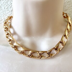May include: A gold-tone chain necklace with a chunky, textured link design.