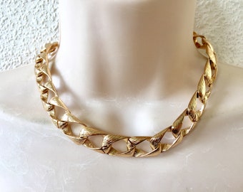 May include: A gold-tone chain necklace with a chunky, textured link design.