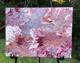 May include: Abstract painting on canvas with swirling patterns in shades of pink, white, and brown. The painting is on an easel.