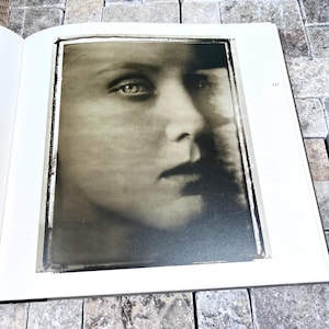 May include: A black and white portrait of a person's face, with a focus on the eyes and lips. The image is framed within a white border and appears to be a photograph or print. The page number "111" is visible.
