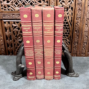 May include: Four antique books with red covers and gold lettering, held by black metal bookends. The books are part of the "International Library of Technology" series, with titles including "Columns Graphical Analysis" and "Arithmetic, Trigonometry and Graphs".