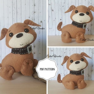 Op de afbeelding: Een bruine vilt hond met zwarte ogen, een witte neus en een zwarte halsband met een zilveren gesp. De hond zit op een houten oppervlak. De afbeelding bevat de tekst "Cutest Voodoo" en "PDF PATTERN".