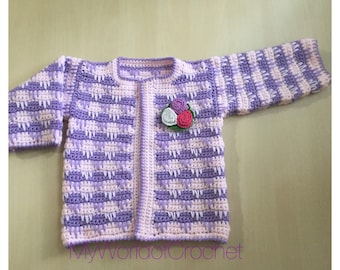 May include: A handmade crochet baby cardigan in shades of lavender and light pink. The sweater features a floral applique and a textured stitch pattern. The text "MyWorldofCrochet" is visible at the bottom. A charming and cozy garment.