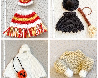 May include: Four sets of crocheted doll accessories: a red, white, and yellow poncho with a matching hat; a black witch hat, skirt, and broom; a white ghost cape with a pumpkin bucket; and a tan roasted turkey with two drumsticks.