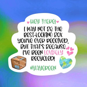 May include: A white sticker with a pink heart and the text "Hey THERE! I MAY NOT BE THE BEST-LOOKING BOX you've ever received, BUT THAT'S Because I'VE BEEN LOVINOLY RECYCLED! #YAYGREEN" with a cartoon drawing of a cardboard box and a globe with the text "Vivid pineap" on both.