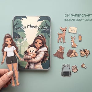 Könnte beinhalten: Ein DIY-Bastelset mit Waldthema. Das Set enthält eine Papierpuppe, ein Journal mit dem Text "Sunday Morning Hike" und verschiedene Waldtier-Ausschnitte. Die Puppe hält einen Papierausdruck von sich selbst. Der Text "DIY Papercraft Instant Download" ist ebenfalls sichtbar.