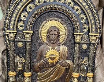 May include: A carved wooden relief of Jesus Christ with a golden heart and thorns, surrounded by an ornate black and gold frame.