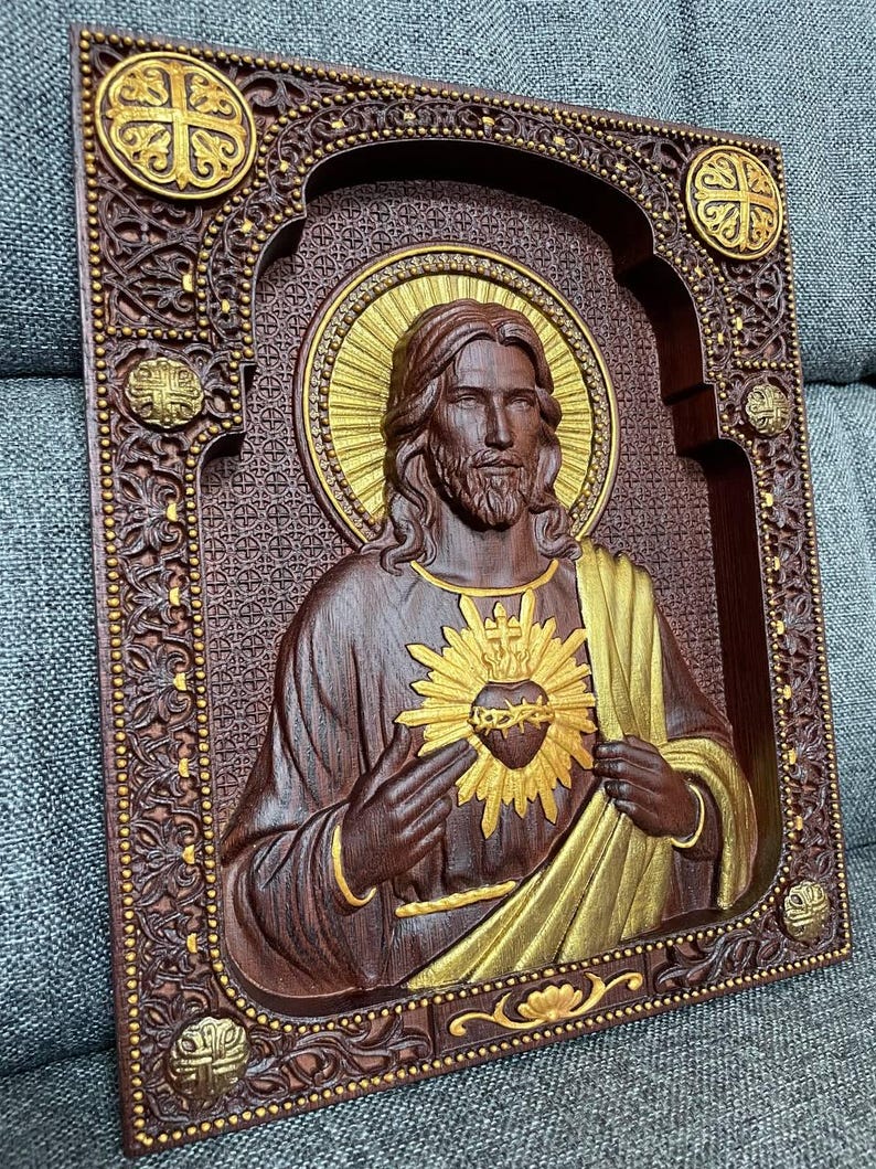 K&ouml;nnte beinhalten: Eine rechteckige Wandplatte aus Holz mit einem geschnitzten Relief des Heiligsten Herzens Jesu. Die Figur ist mit einem goldenen Heiligenschein und einem strahlenden Herzen dargestellt, vor einem dunkelbraunen Hintergrund mit floralen Details.