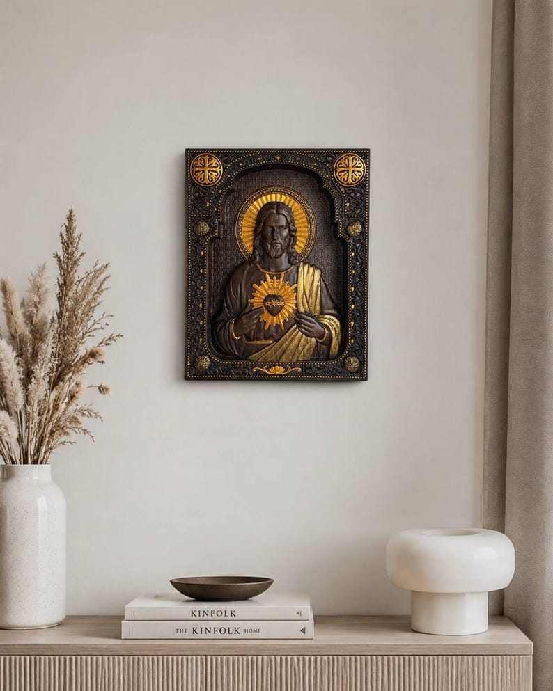 K&ouml;nnte beinhalten: Eine rechteckige Wandplatte mit einem dunkelbraunen Relief des Heiligsten Herzens Jesu. Die Figur ist in einem verzierten, dunklen Rahmen mit goldenen Akzenten zentriert. Jesus ist mit einem goldenen Heiligenschein und einem strahlenden Herzsymbol dargestellt.
