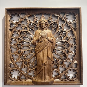 Puede incluir: Una escultura de pared de madera de Jesucristo con un coraz&oacute;n en el pecho, rodeada de un marco de madera tallada con un dise&ntilde;o de ventana de vidriera.