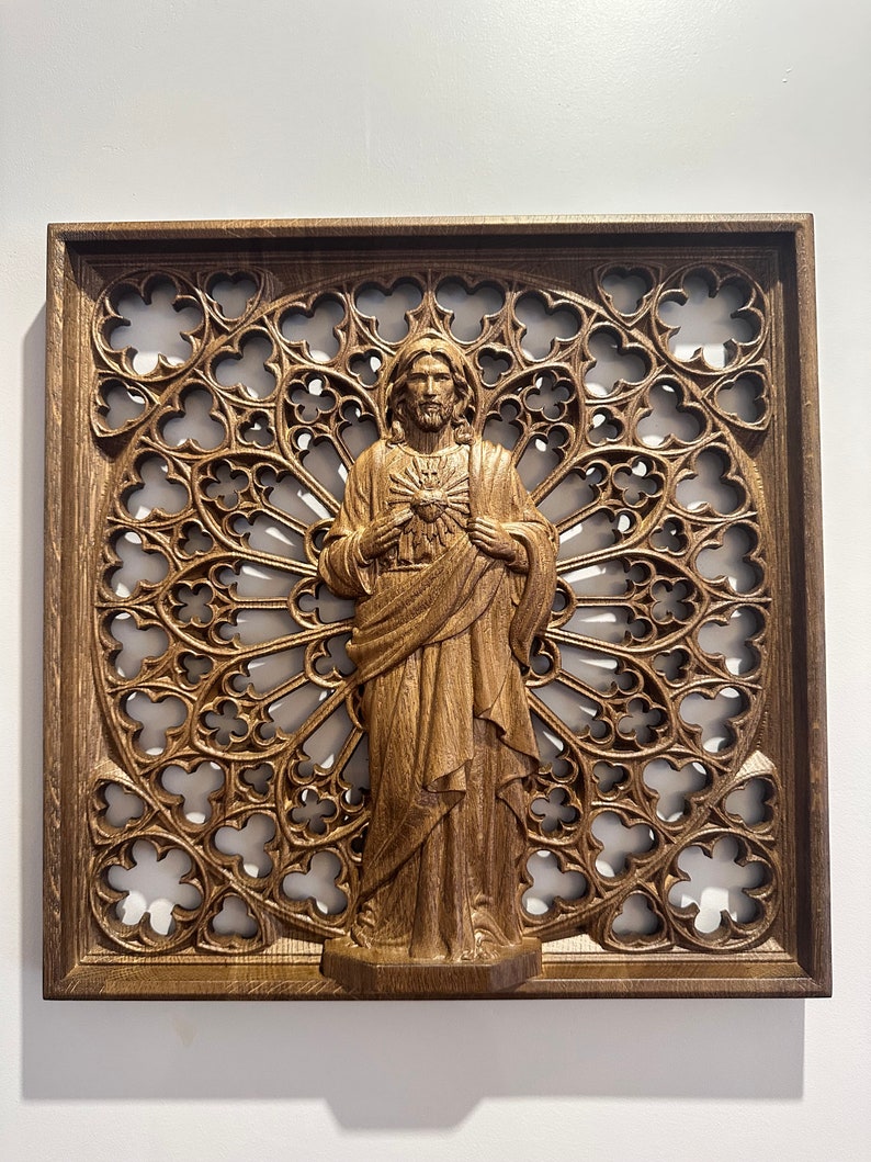 Puede incluir: Una escultura de pared de madera de Jesucristo con un coraz&oacute;n en el pecho, rodeada de un marco de madera tallada con un dise&ntilde;o de ventana de vidriera.