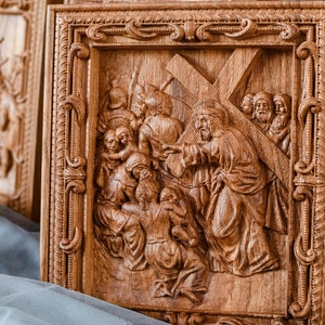 Puede incluir: Una talla de madera que representa una escena religiosa. La talla muestra a Jesús llevando una cruz, rodeado de otras figuras. La talla es detallada e intrincada, con un color marrón cálido.