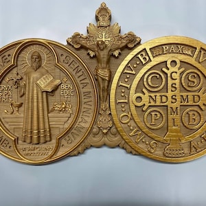 May include: A gold-toned wooden wall plaque featuring a depiction of Saint Benedict, the crucifix, and the Miraculous Medal. The plaque includes the Latin inscription "Eius in obitunro pre", "Sentiam muniamur", "Ben edic ti", "Crux spa tris", "Pax VRSNSS", "C S NDS MDO MB", "INRI", and "O.W.S. L.I.V.B.T.O.W.M.S."
