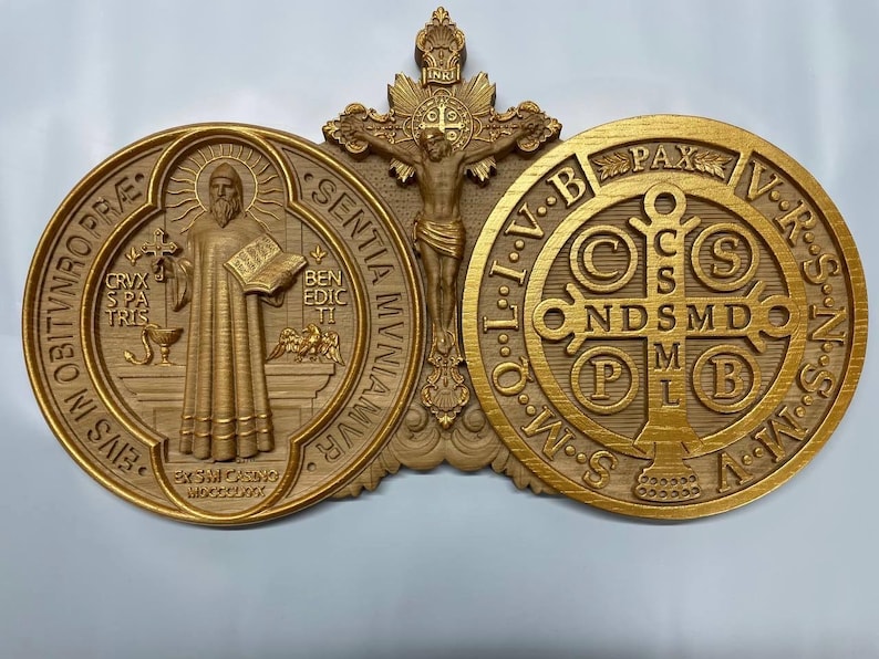 May include: A gold-toned wooden wall plaque featuring a depiction of Saint Benedict, the crucifix, and the Miraculous Medal. The plaque includes the Latin inscription "Eius in obitunro pre", "Sentiam muniamur", "Ben edic ti", "Crux spa tris", "Pax VRSNSS", "C S NDS MDO MB", "INRI", and "O.W.S. L.I.V.B.T.O.W.M.S."