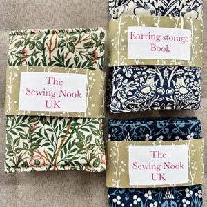 May include: Earring storage books and fabric bundles with floral patterns in green, pink, and blue. The books are labelled "Earring storage Book" and "The Sewing Nook UK."