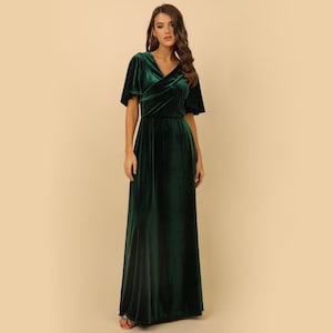 May include: A long, dark green velvet dress with a V-neckline and short, flutter sleeves. The dress has a wrap-style bodice and a flowing skirt.