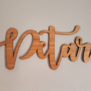 May include: A wooden sign with the word "Petar" written in cursive script.