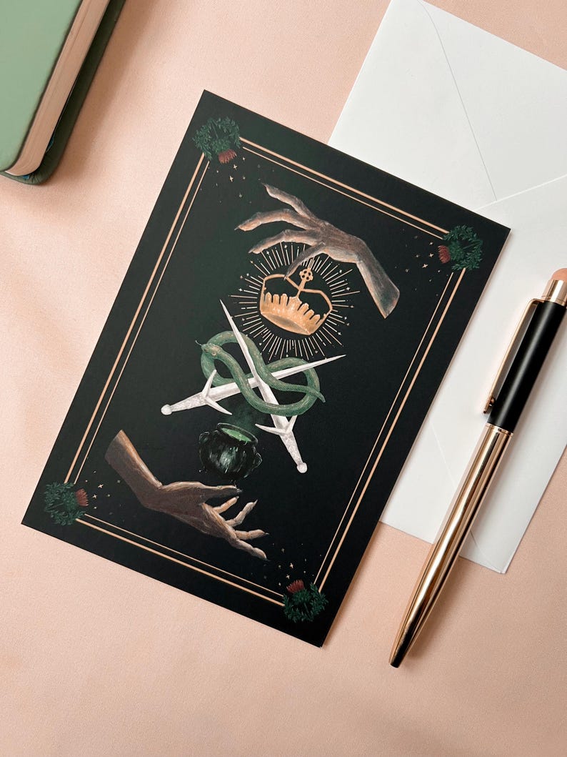 Illustrated Macbeth postcard
picturing witchy hands, golden crown, a snake wrapped around two daggers, and a couldron. There is a thistle in each corner, and two golden lines decorating all 4 sides of the card.