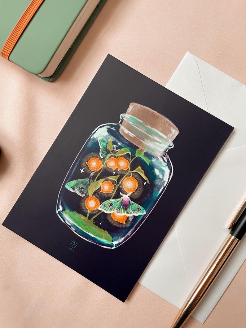 Illustrated postcard of a glass jar. Three emperor moths are drawn to the light of the little Chinese Lanterns. 
Dreamy cottagecore illustration inspired by the falling darkness of autumn evenings.
The photo also shows an envelope that is included.