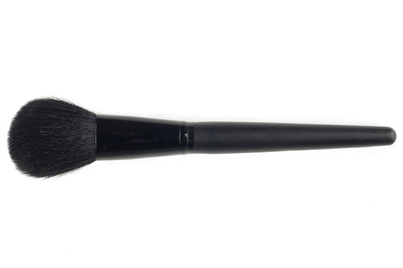May include: A black makeup brush with a round, fluffy head and a long, black handle.
