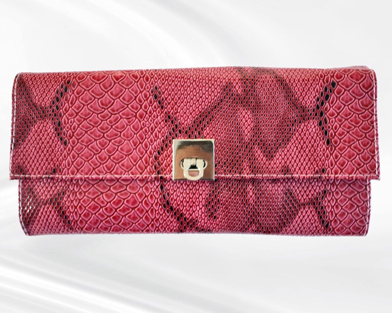 May include: A pink snakeskin clutch with a silver clasp.