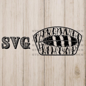 Peut inclure: Conception SVG en noir et blanc représentant une plume à l'intérieur d'un cadre décoratif avec un fond en grain de bois. Le mot "SVG" est imprimé dans une police de caractères audacieuse et stylisée à gauche du cadre.
